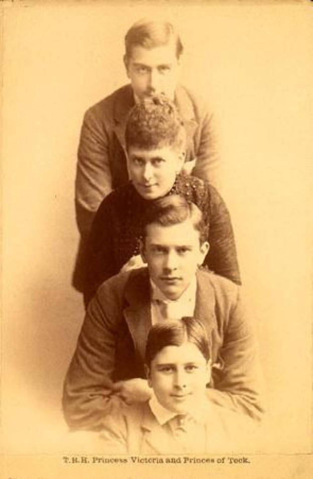 Schwarzes und weißes Foto einer Familie, die zusammen posiert, mit Text unten, der "T.H. Prinzessin Victoria und Prinzen von Rock" liest.