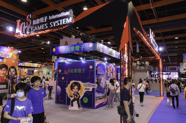 Eine Gruppe von Menschen durchquert einen Konferenzsaal auf einer Gaming-Messe in China, einige tragen Taschen und halten Gegenstände, mit Displaytafeln, Deckenleuchten und Teppichboden.