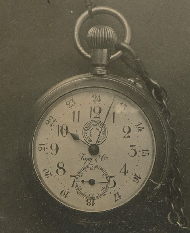 Altes Schwarz-Weiß-Foto einer Taschenuhr mit Kette, mit einer nummerierten Zifferblatt.