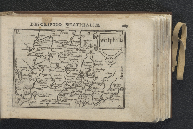 Offenes Buch mit einer detaillierten Karte von Westfalen auf einer schwarzen Oberfläche, die geographische Merkmale zeigt.