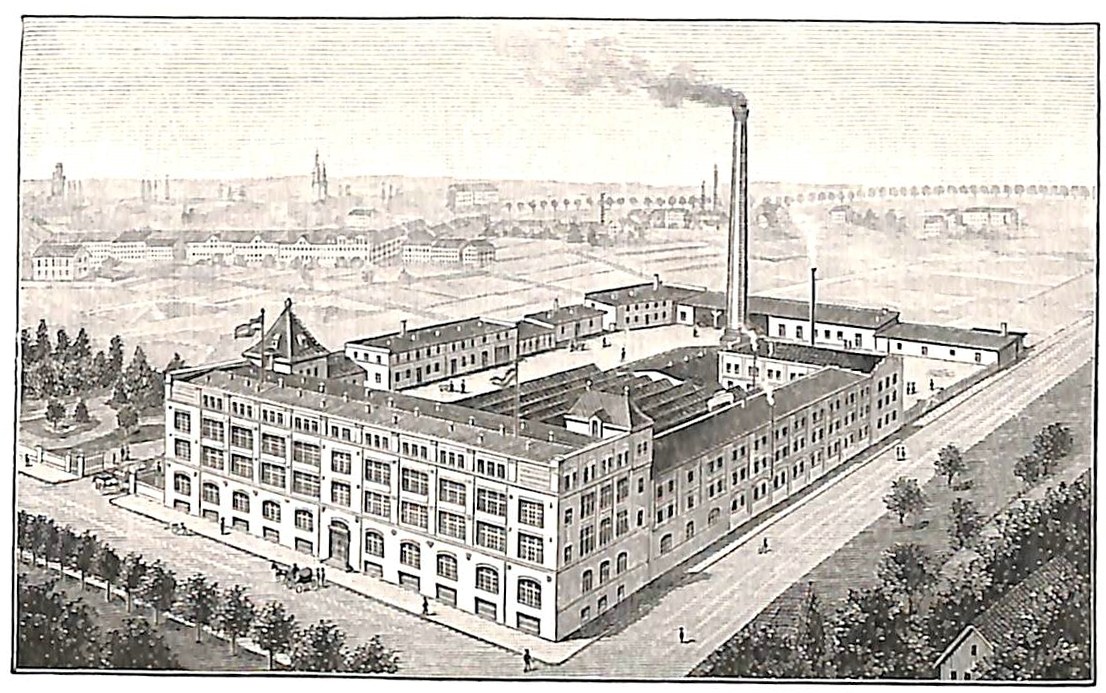 Alte Fabrik mit einem großen zentralen Gebäude, umgeben von Bäumen und Text unten.