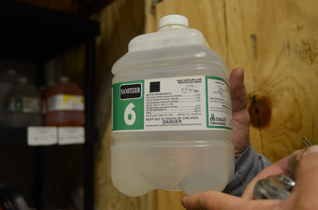 Ein Mann hält eine Flasche Handdesinfektionsmittel.