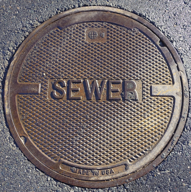 Metall-Schachtdruckdeckel auf der Straße mit der eingravierten Aufschrift "Kanal"