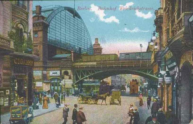 Alte Postkarte zeigt eine belebte Stadtstraße in Berlin, Deutschland, mit Fußgängern, Pferdewagen, Gebäuden, Laternen, einer Brücke und einem bewölkten Himmel, mit Text oben.