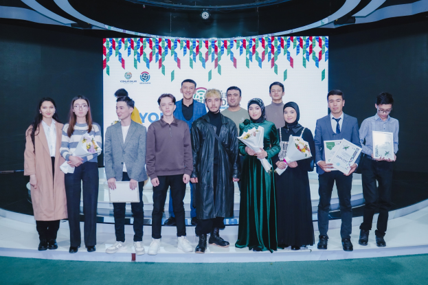 Gruppe von Menschen auf einer Bühne mit Blumensträußen und Urkunden, mit einem "Youth Solar Awards 2019"-Hintergrund.