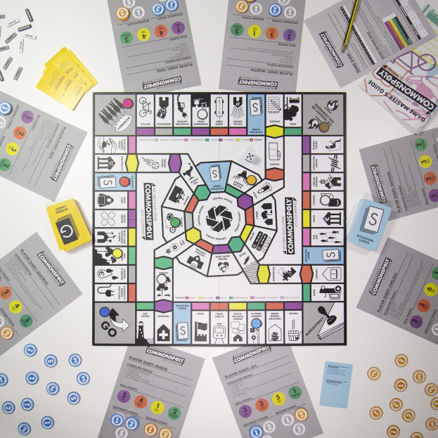 Ein Monopoly-Brettspiel auf einem Tisch mit Spielkarten, Papieren und einem Bleistift, der herumliegt.