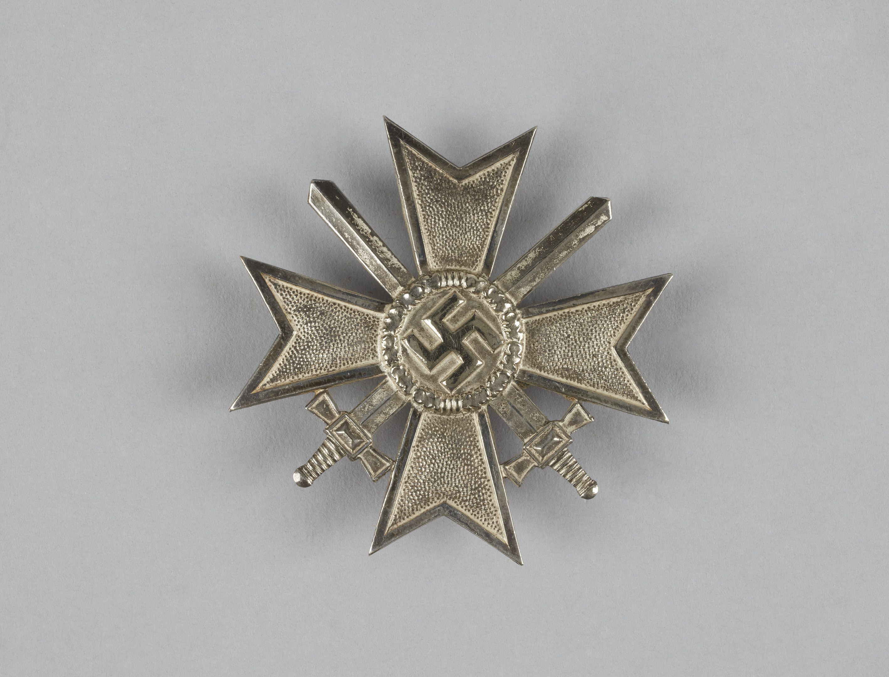 Silberne Medaille in Form eines Kreuzes mit dem Orden vom Stern der deutschen Kaiserreiche, dargestellt auf einer weißen Oberfläche.