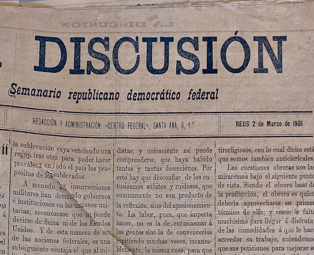 Ein vergilbtes, leicht zerknittertes Zeitungsblatt mit der schwarzen Schrift "Diskussion", das die Schlagzeile "Semanario Repúblicano Democrático Federal" trägt.