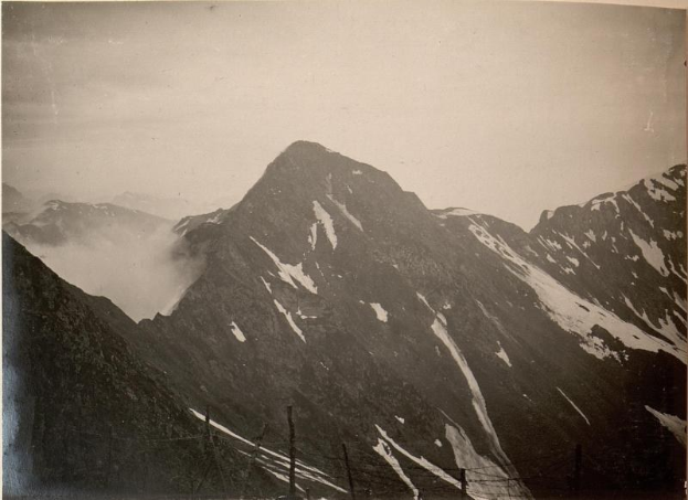 Schwarzes Foto einer Gebirgskette mit schneebedeckten Gipfeln und einem klaren Himmel, beschriftet mit "Mount Everest, Neuseeland" unten.