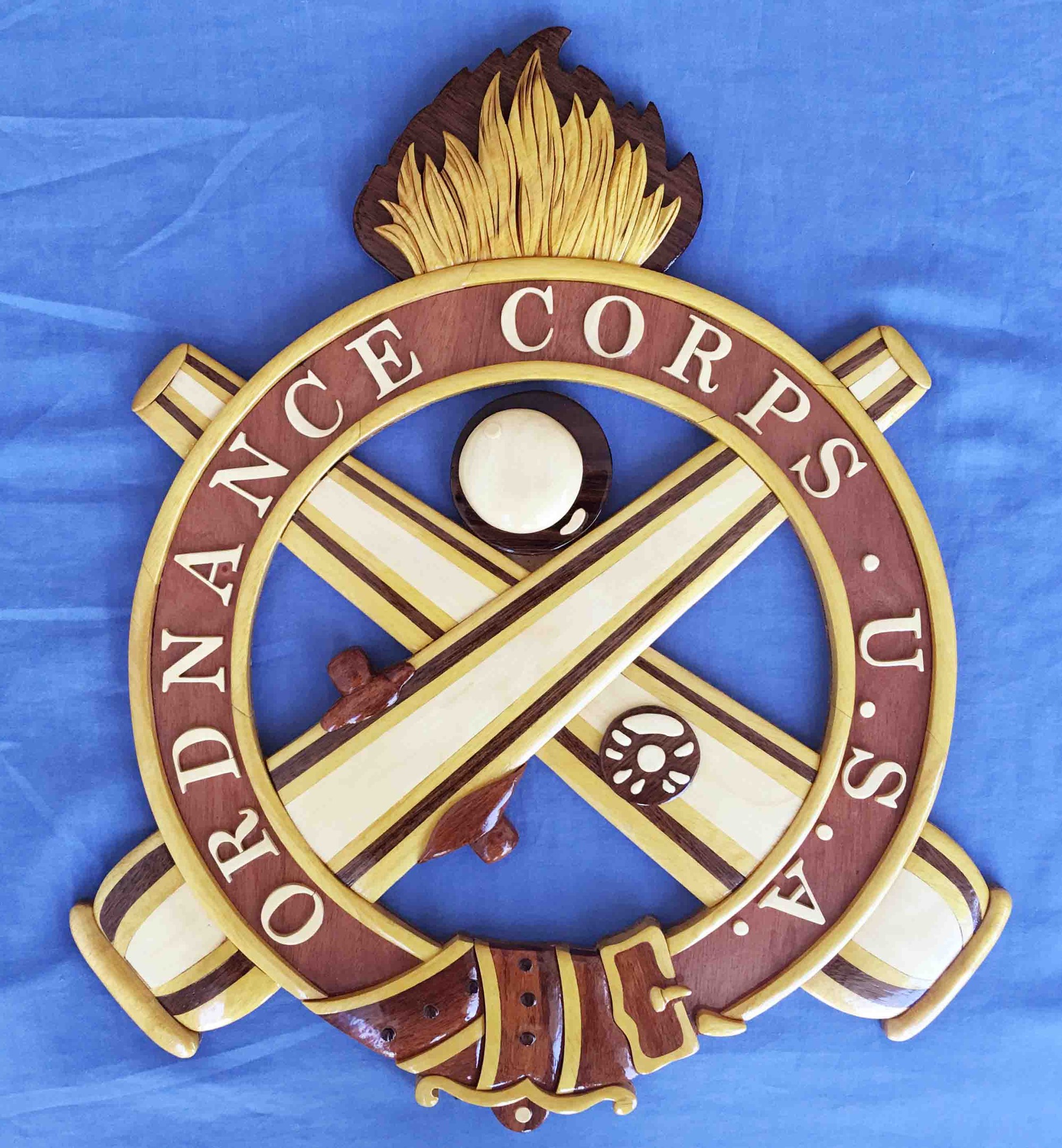 Holzschild mit "Ordnance Corps"-Text, mit einem navyblauen Hintergrund, weißer Stern, goldener Umrandung und schwarzer Schrift, auf blauem Tuch montiert.